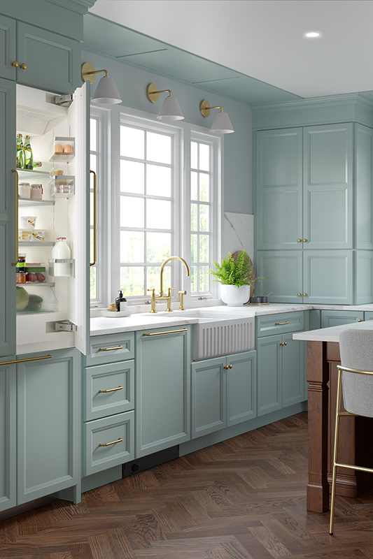 A mint-green kitchen with white sink and refrigerator concealed within the cabinetry. 