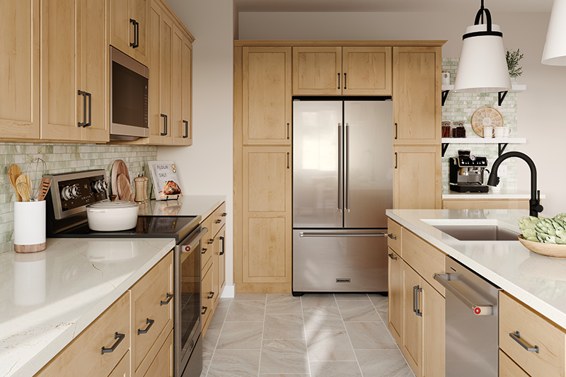 A kitchen with soft natural lighting, light wooden cabinets, ivory-colored marble countertops, and a light green-colored tile backsplash. 
