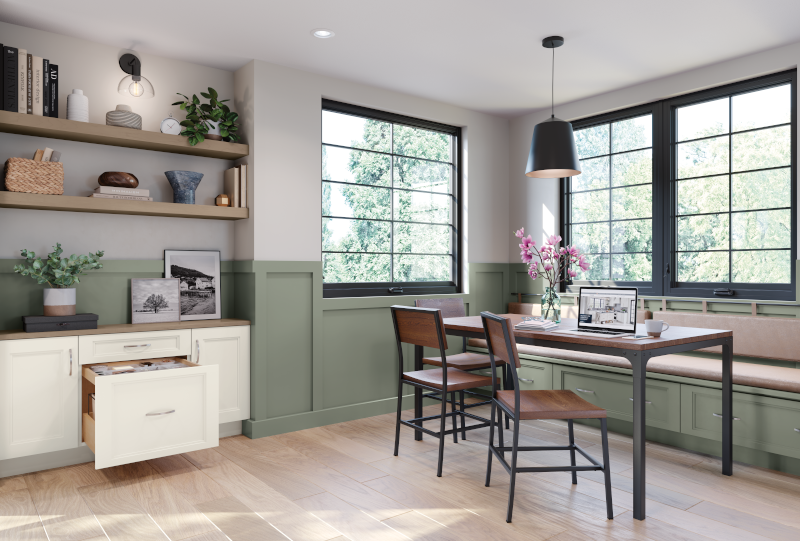 A work and study zone adjacent to the kitchen set with wooden table, wooden chairs, and built-in bench for seating on the other side. Custom cabinets show an opened drawer for papers and filing, and dark-pained windows provide ample natural lighting for a relaxed work space. 