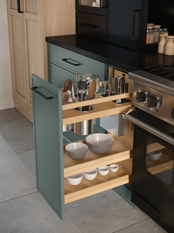 This is a close-up view of an organized kitchen cabinet pull-out to the right of the oven. This cabinet reveals three shelves that cleverly organize bowls on the bottom two shelves, and utensils at the top. 