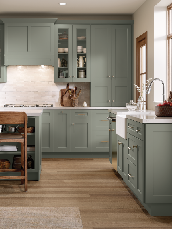 A kitchen with cabinets painted the gray/green color of Dusty Miller.