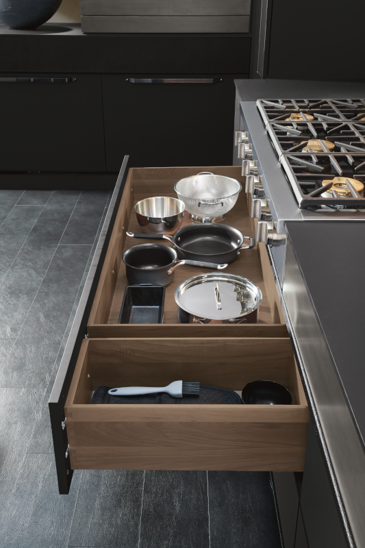 Pull-out cabinet drawers with pots, pans, and utensils inside.