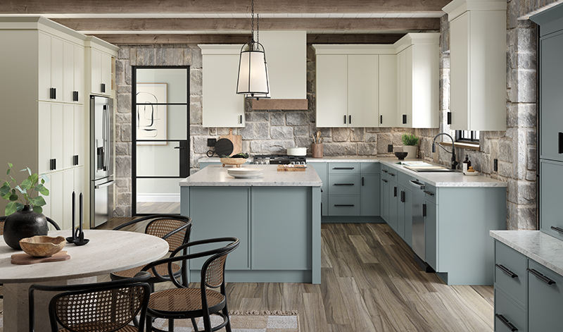 A kitchen with light blue lower kitchen cabinets, off-white upper cabinets, stone walls, and a dining table. 