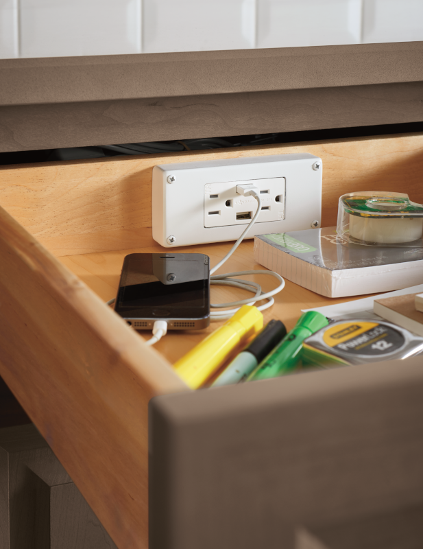 A kitchen cabinet drawer becomes a charging station as well as a storage solution for office supplies.