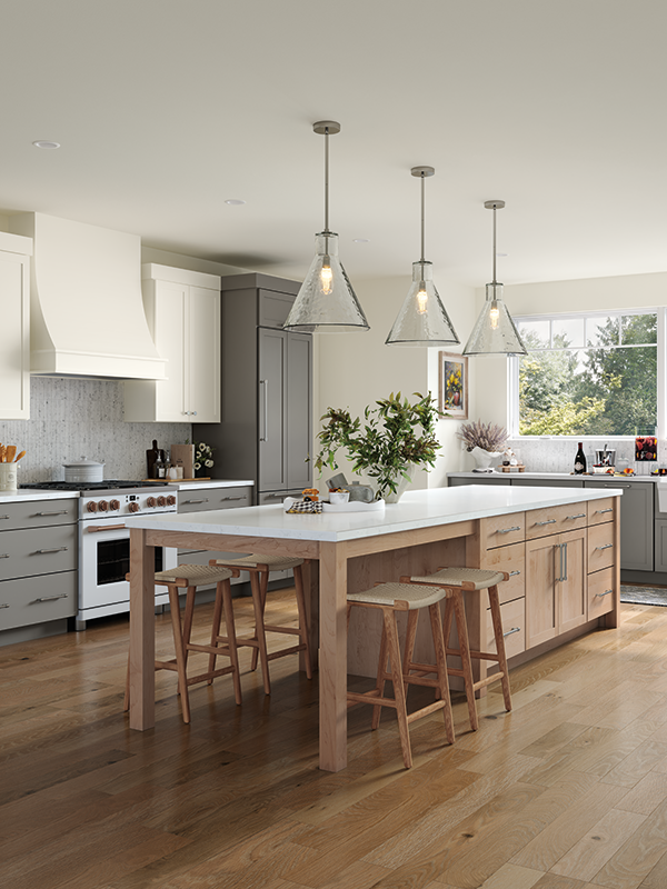 This open kitchen features a large kitchen island with white marble countertop, which extends from the main hub on the right, to form a table-like section to the left of the island, where four barstools are set. Natural lighting comes in from the right, while light-wooden textures and soft grey tones make up the cabinet design. 