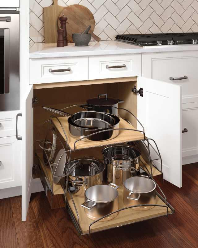 A lower kitchen cabinet with pull-out drawers for organization of pots and pants, which are set on two-tiers of shelves. 