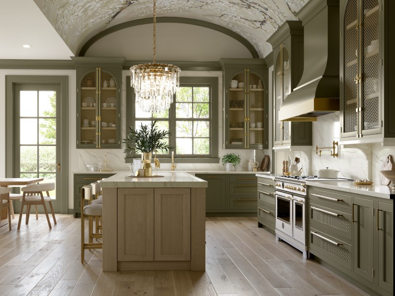 This kitchen features bold architectural details which include a glass chandelier that hangs above the kitchen island, an arched high ceiling, and plenty of brass-toned hardware throughout, with sage green cabinetry. 