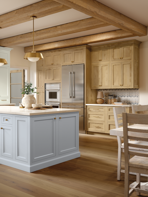 A kitchen with stained wood cabinets and a light blue painted island.