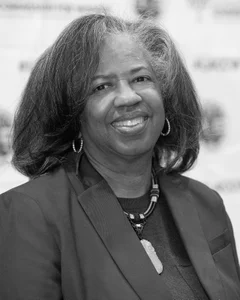 Woman smiling for a photo in black and white.
