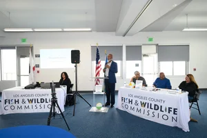 A man speaking at a FWC event with people sitting on both sides of him
