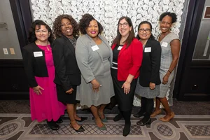 6 women smiling for a photo.