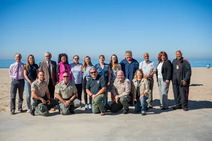 a group photo of people in front of the beach