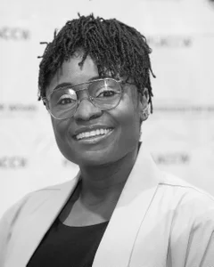 Woman smiling for a photo in black and white.