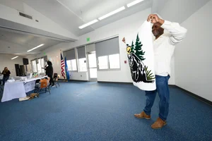 A man holding up a drawn picture of the FWC logo.
