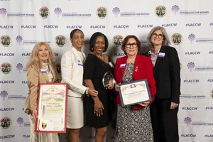 5 women smiling and holding up a few awards.