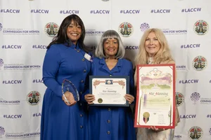 3 women each holding up an award and smiling.