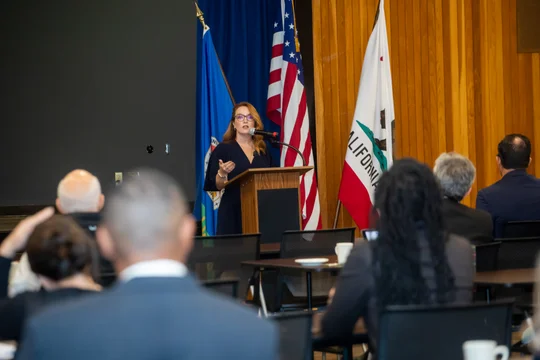 Supervisor Horvath speaking at a podium in front of an audience.