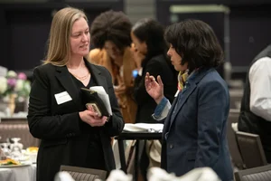 2 women speaking to each other.