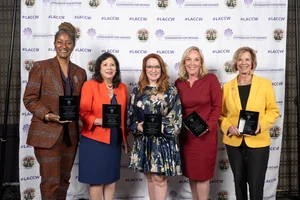 The 5 supervisors holding up awards while smiling for a photo.