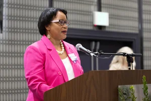 Woman in pink speaking at a podium.