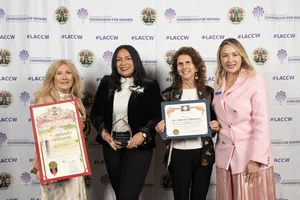 4 women smiling and holding up a few awards.