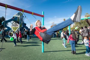 Supervisor Hahn swinging at the Holifield Park Playground Ribbon Cutting