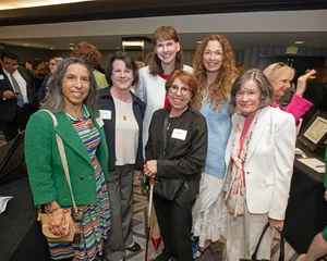 6 women smiling for a photo.