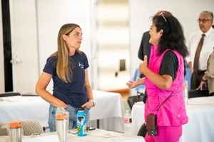 2 women speaking to each other at event