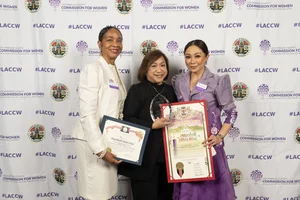 3 women smiling and holding up awards.