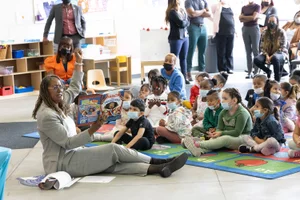 Supervisor Mitchell reading a children's book to a group of kids