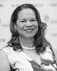 Woman smiling for a photo in black and white.