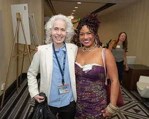 2 women smiling for a photo.