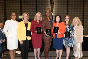 the supervisors holding up awards and smiling with a couple other women.
