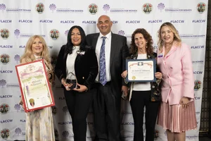 A group of people smiling and holding up a few awards.