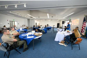 A group of people sitting at different tables at some sort of event.