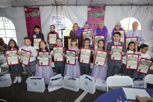 Supervisor Barger posing with a group of young children holding up awards