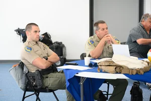 2 officers sitting at a table at an event.