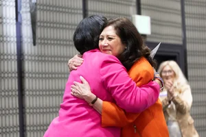 Supervisor Holis hugging on stage.