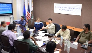 Group meeting photo in an office at a table.