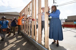 Supervisor Mitchell holding wood at a construction site