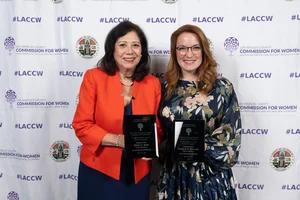 Supervisor Holis and Supervisor Horvath smiling for a photo while holding up awards.
