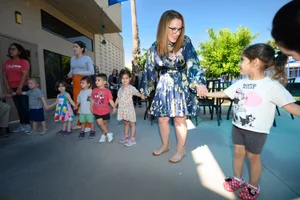 Supervisor Horvath holding the hands of young children in a line