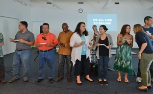 Group photo of people talking and holding papers.