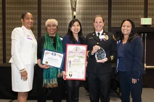 a group of women holding up a few awards.