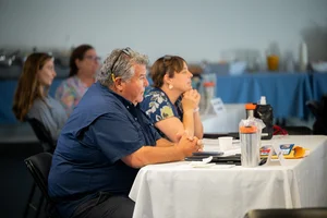 a group of people sitting at tables at an event.
