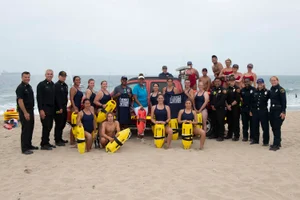 Supervisor Mitchell group photo with lifeguard/beach team on the sand