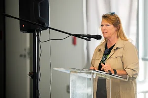 a woman speaking at the podium at the event