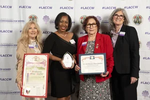 4 women smiling and holding up a few awards.