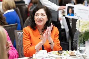 Supervisor Holis clapping while sitting at a table.