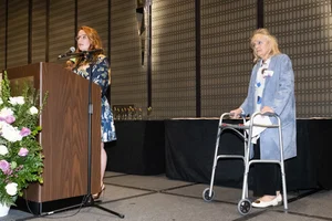 Supervisor Horvath speaking at the podium with a woman standing next to her.